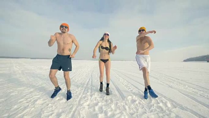 三个快乐的朋友在锻炼身体时在雪地上跳跃。