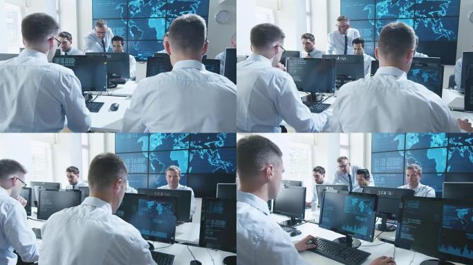 团队IT安全专业人员在充满显示器的明亮监控室工作