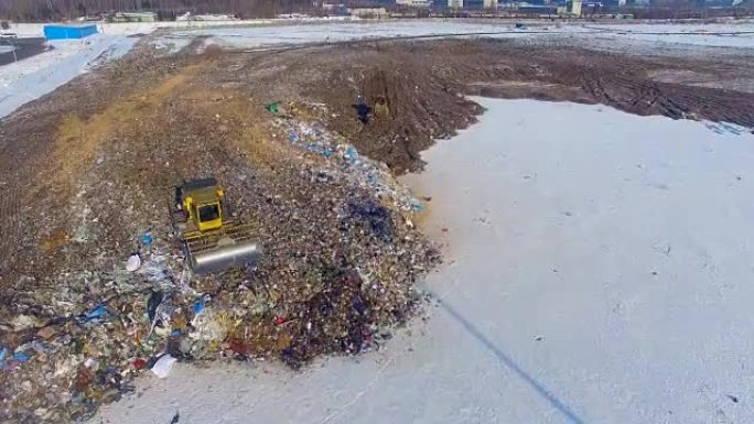 一个大型垃圾填埋场，有两台作业压实机拖拉机。