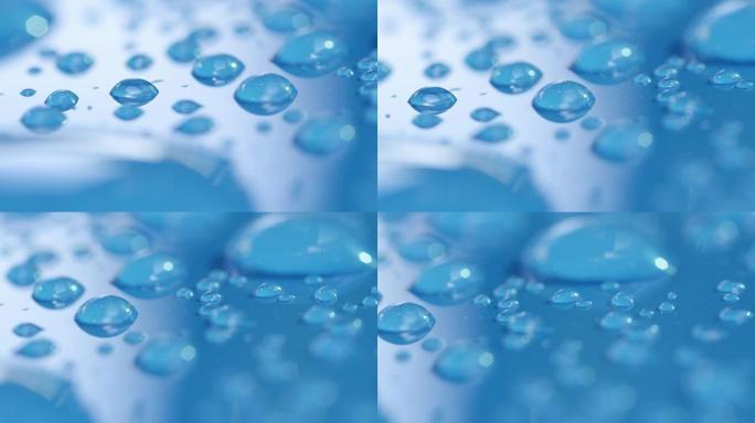 Dop，宏观，关闭大大小小的雨滴，在蓝色表面上形成图案。