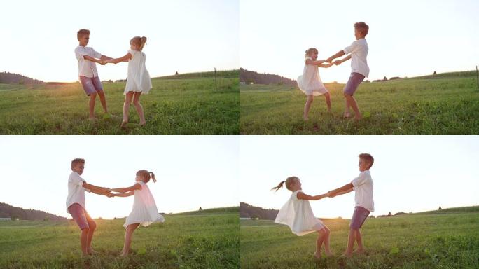 慢动作开朗的孩子们在金色日落时牵着手在草地上跳舞