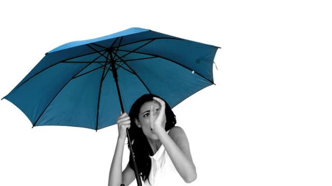 蓝色雨伞下的女人因恐惧而畏缩