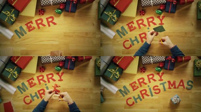 一名男子剪字母 “圣诞快乐”，并用礼品盒将其放在木桌上的俯视图延时。