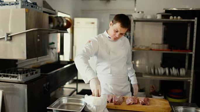 专业厨师在餐厅厨房的切菜板上准备带有香料的排骨