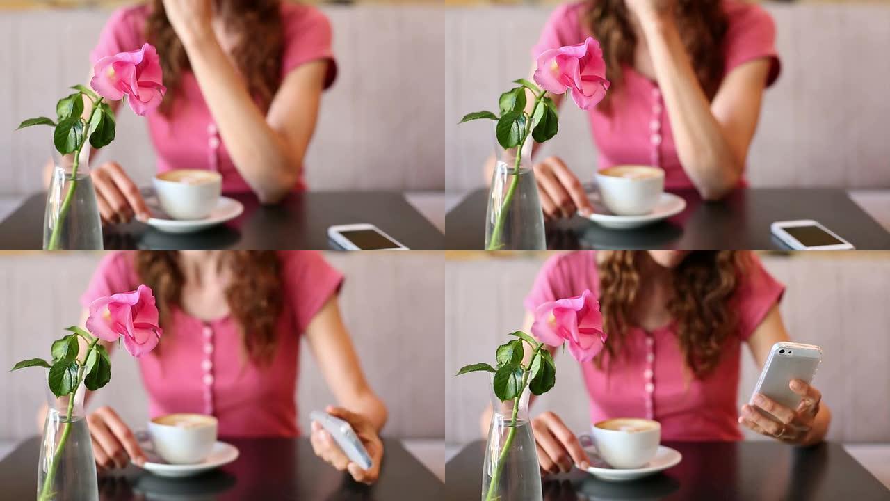 女人在看手机喝咖啡
