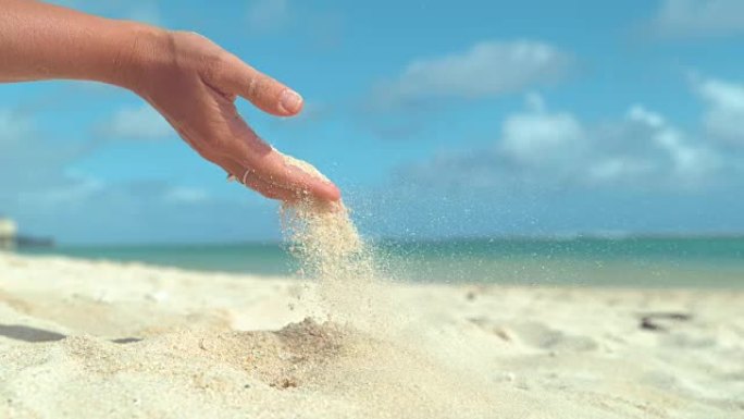 慢动作: 小沙粒从无法辨认的女性手中慢慢滑出。
