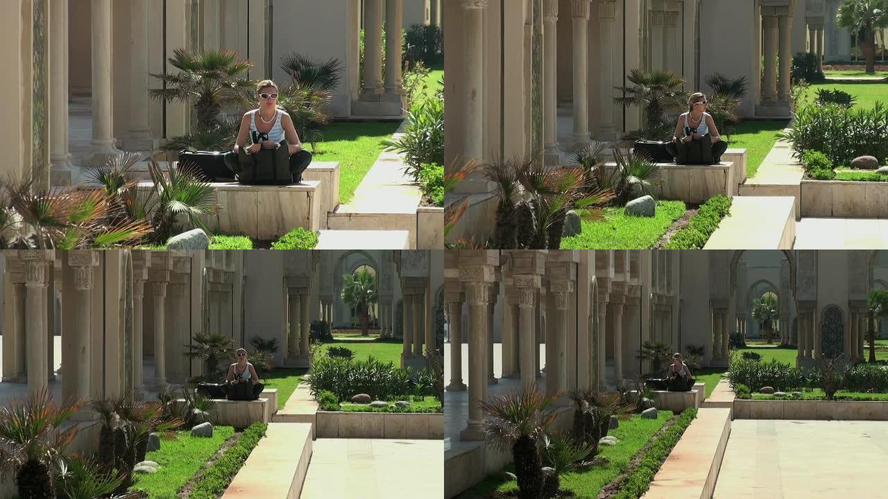 女游客在卡萨布兰卡哈桑二世清真寺花园休息