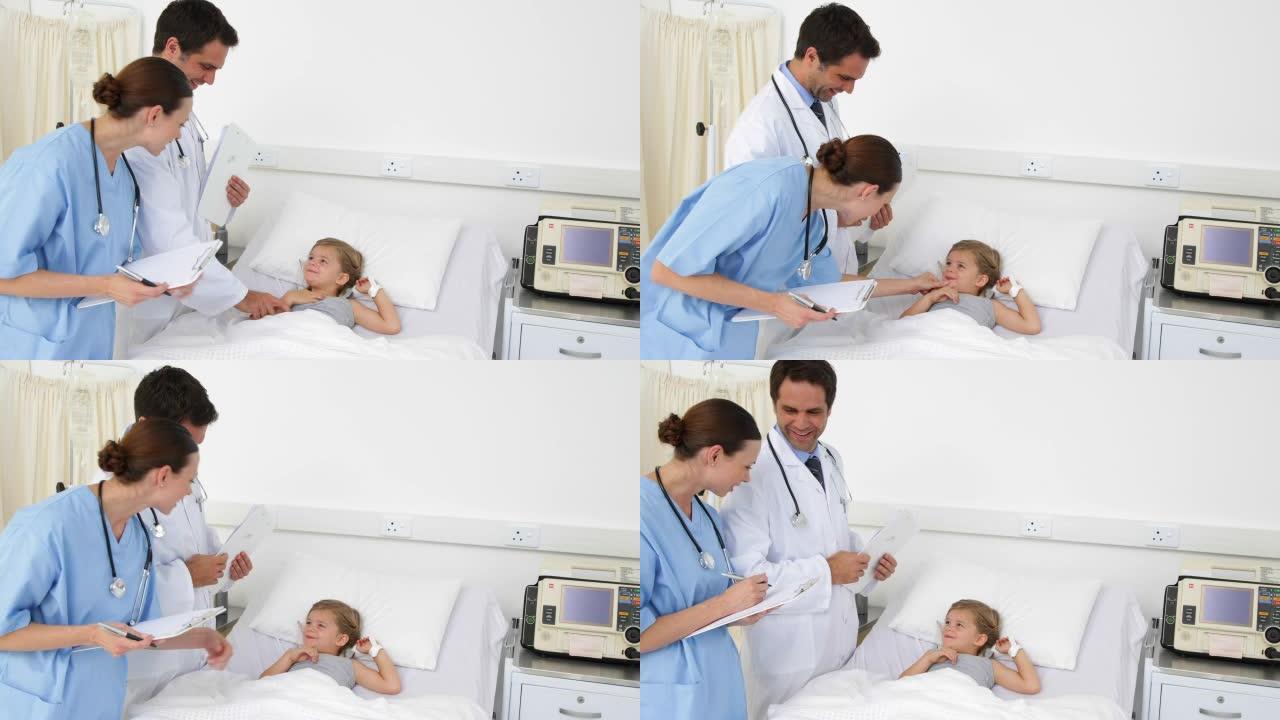生病的女孩躺在床上与护士和医生交谈