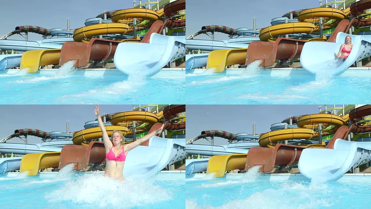 慢动作: 开朗的女人在炎热的夏日滑下滑下滑入有趣的水上乐园的游泳池