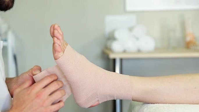 物理治疗师在患者受伤的脚上绑上绷带