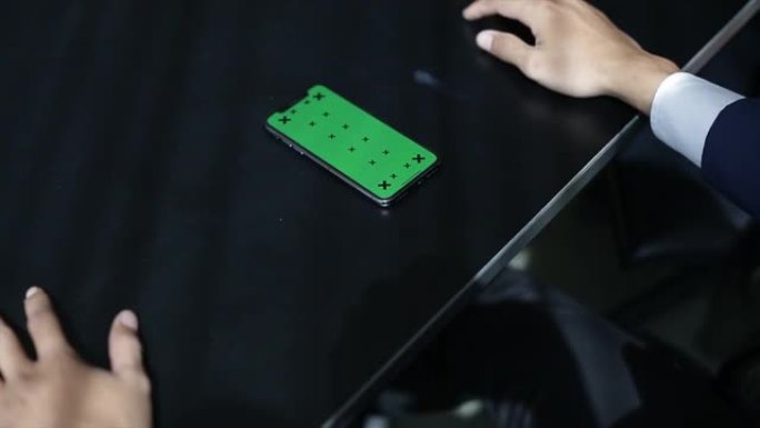 手在木桌上用绿屏手机