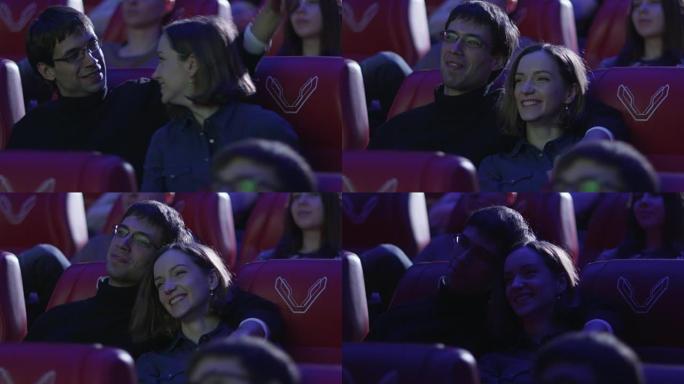 年轻幸福的浪漫夫妇正在电影院看电影放映。