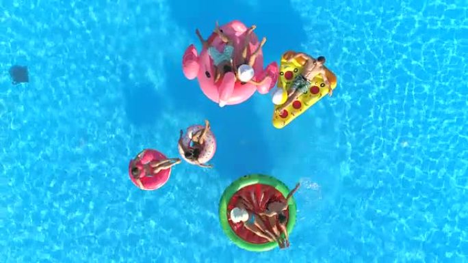 空中: 年轻人在充气西瓜和甜甜圈上玩得开心