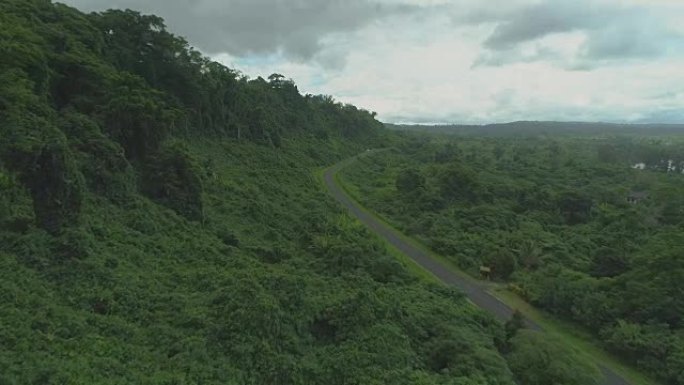 空中: 令人惊叹的郁郁葱葱的绿色自然在空旷的道路附近的山坡上过度生长。