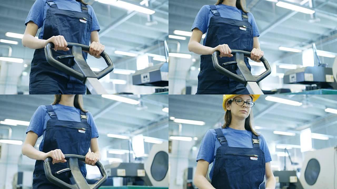 漂亮的安全帽女工在一个大工厂大楼里操作托盘提升机。