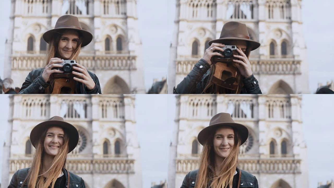 在法国巴黎，年轻的微笑女子站在巴黎圣母院附近并在胶片相机上拍照的肖像