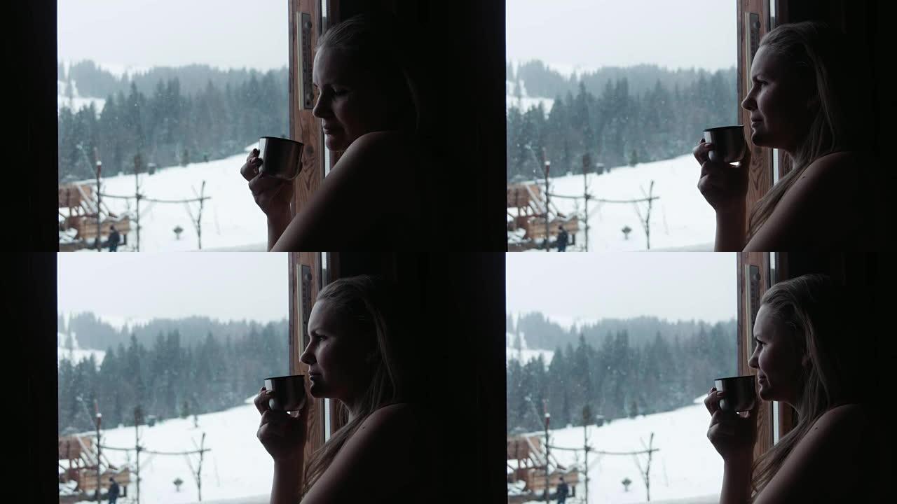 冬季，女性在度假胜地的窗户附近喝茶