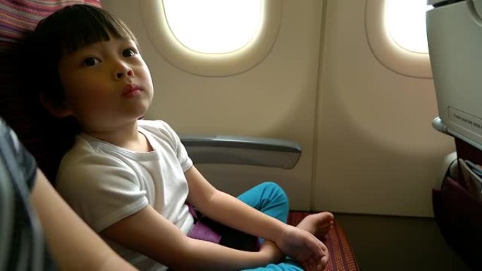 安全概念小男孩在飞行旅行期间在飞机上阅读安全说明。