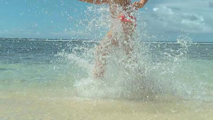 慢动作特写: 无法识别的女孩在沙滩上的浅海中奔跑