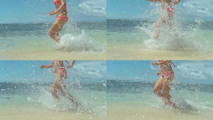 慢动作特写: 无法识别的女孩在沙滩上的浅海中奔跑