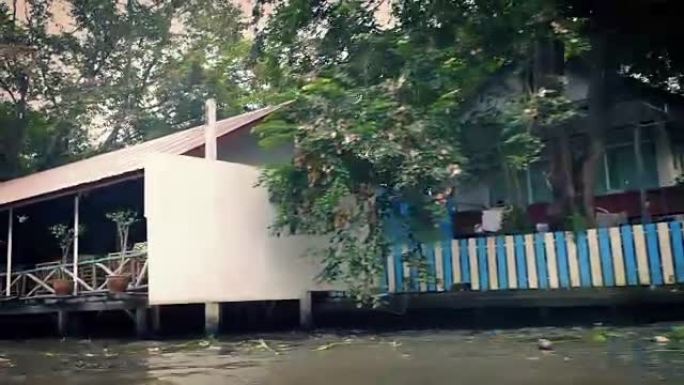 船POV经过热带景观中的河边房屋