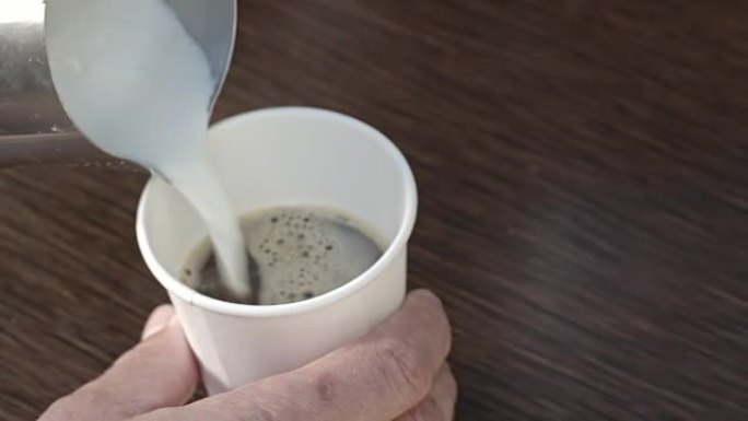 男性咖啡师将咖啡倒入杯子中