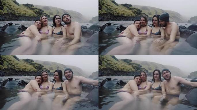 一群年轻人在冰岛山区的温泉上放松。享受天然水疗的游客