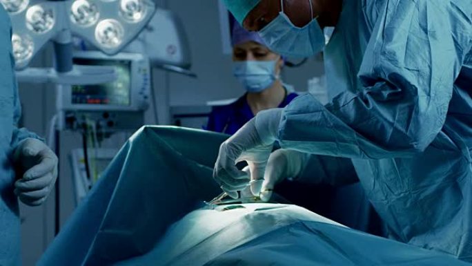 在医院手术室中，由专业外科医生和护士组成的多元化团队在成功手术后缝合伤口。