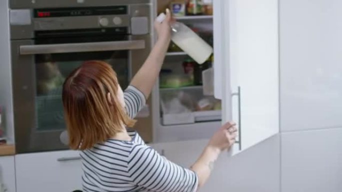 截瘫妇女把牛奶放进冰箱