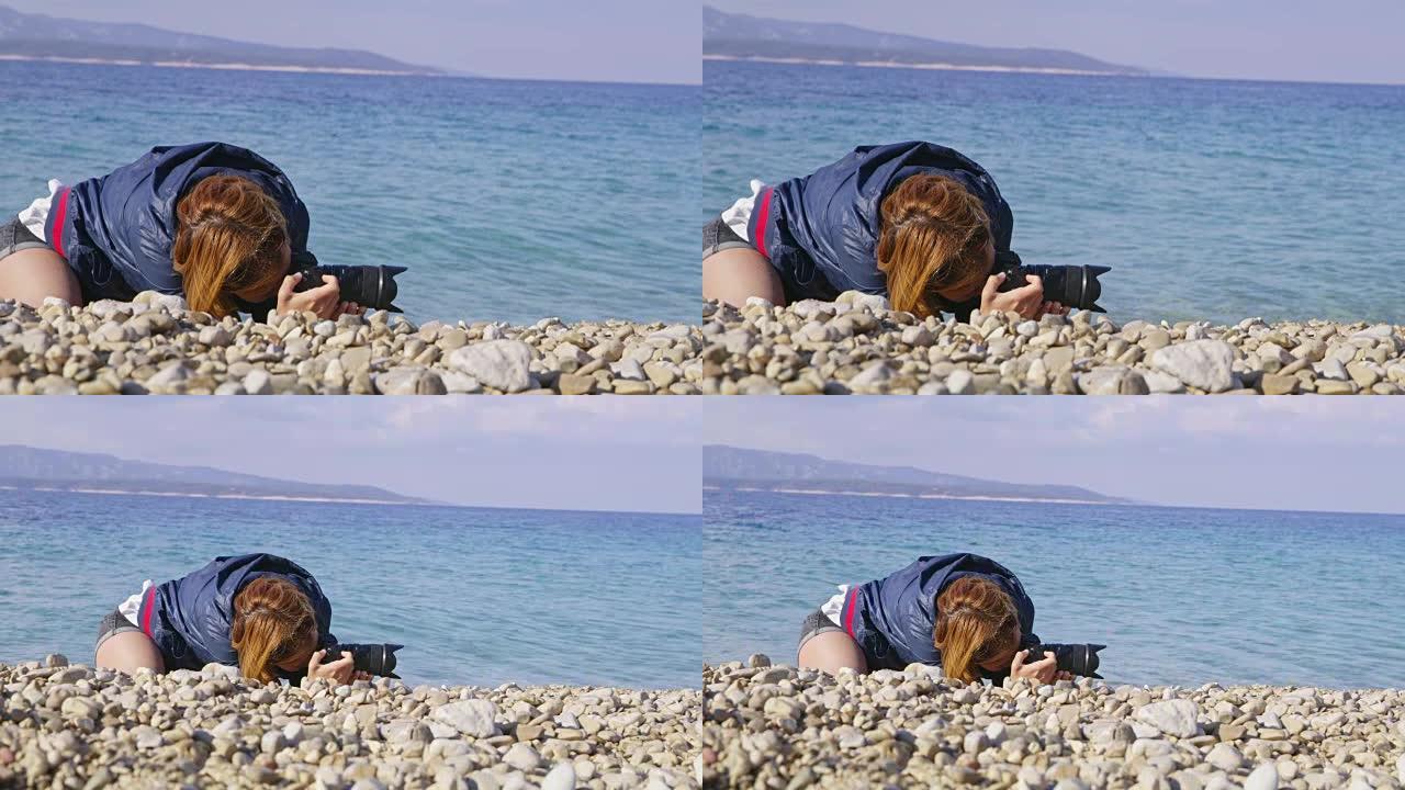 女士女摄影师在阳光明媚的海洋海滩上使用数码相机
