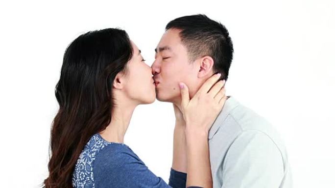 快乐的亚洲夫妇亲吻和微笑
