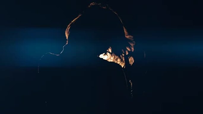 一个女孩在黑暗中拳击的中段镜头。