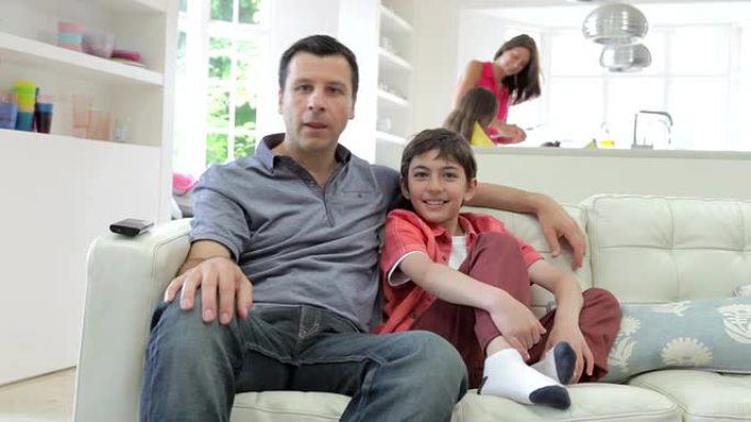 西班牙裔家庭坐在沙发上一起看电视