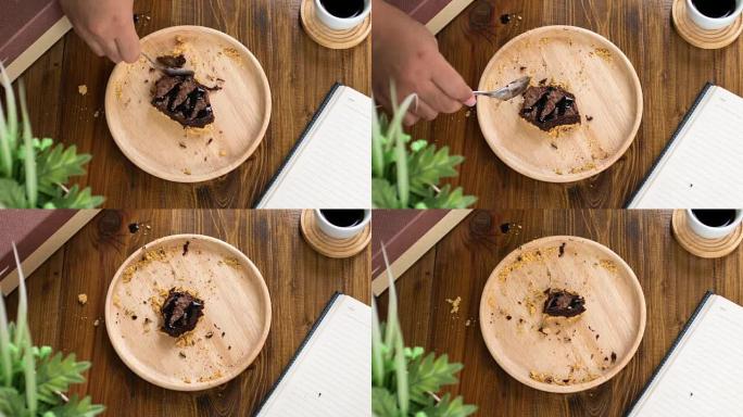 时间流逝: 在木盘和木桌上吃布朗尼巧克力蛋糕