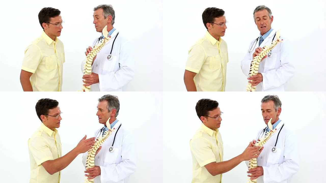 医生拿着脊柱模型与病人交谈