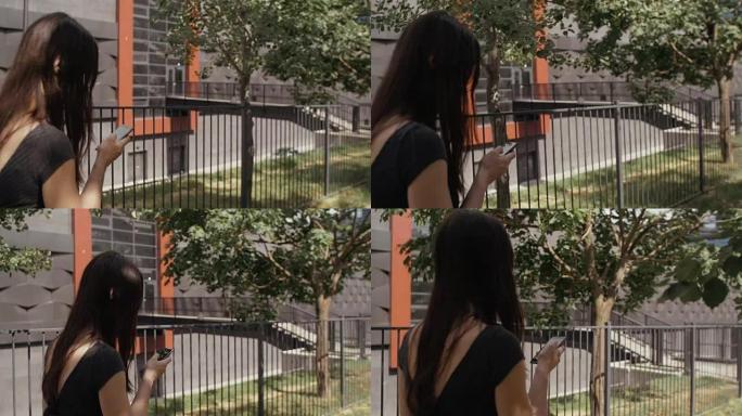 性感的女商人使用智能手机在城市街道的人行道上行走，steadicam拍摄。慢mo