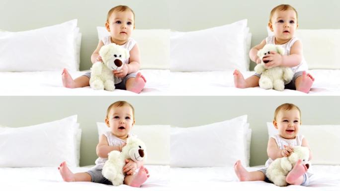 可爱的女婴在床上玩毛绒玩具