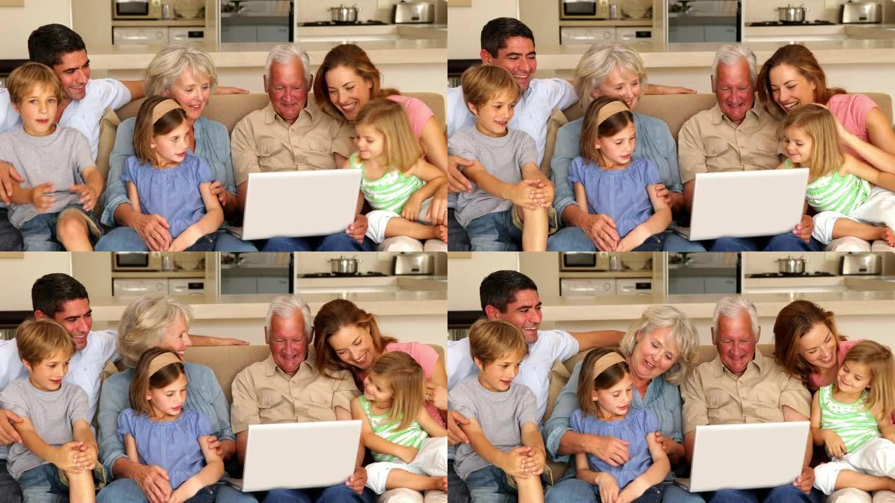 大家庭一起在沙发上使用笔记本电脑