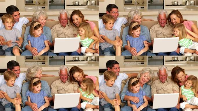 大家庭一起在沙发上使用笔记本电脑