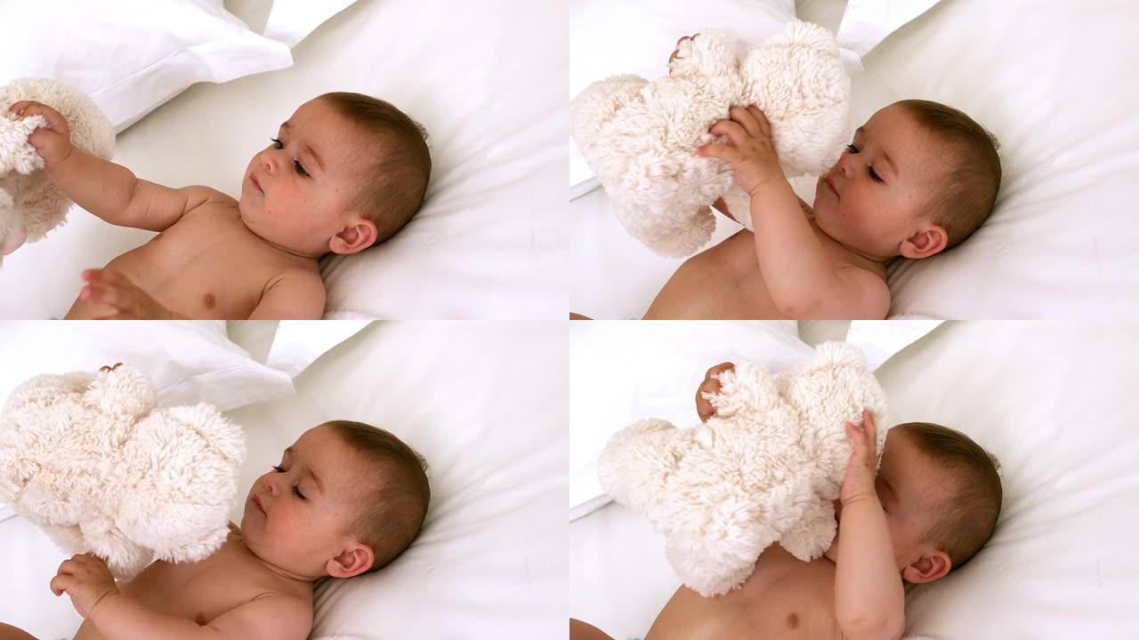 可爱的婴儿和泰迪熊在床上