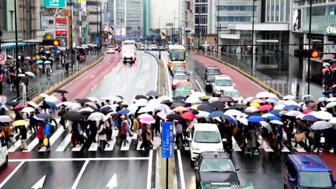 日本人人群的慢镜头在日本东京新宿商圈的新宿JR车站的建筑物之间过街。