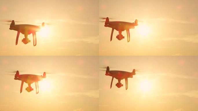 慢动作特写镜头耀斑: 在金色日落天空上飞行的小型拍摄无人机