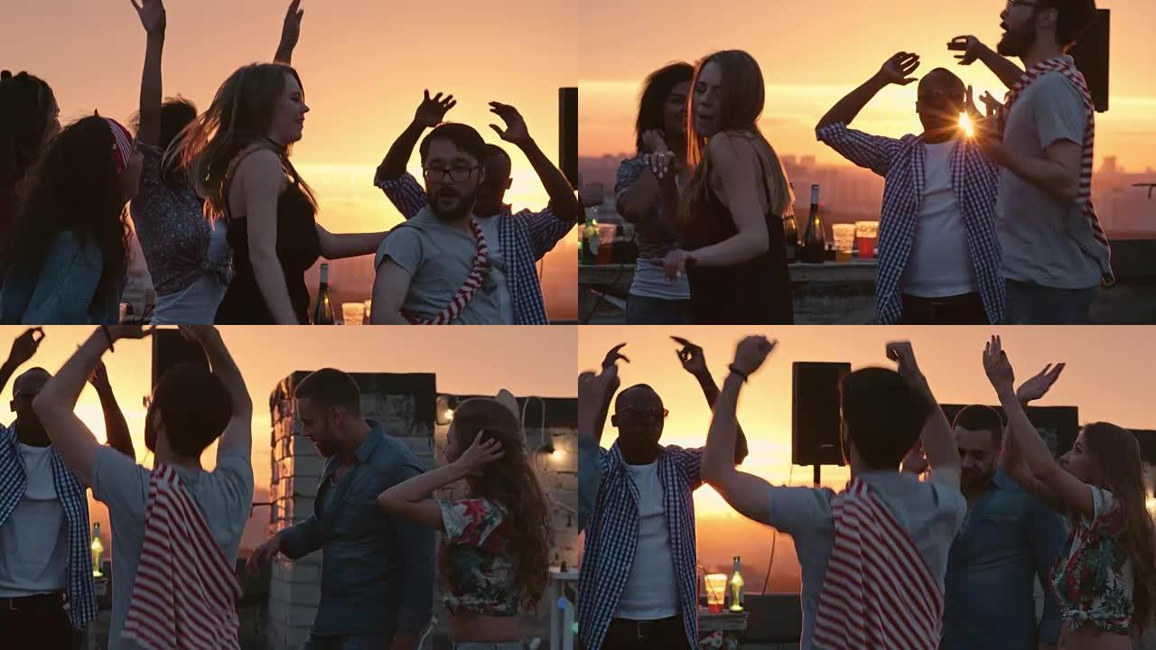 派对朋友在日落时在屋顶上跳舞