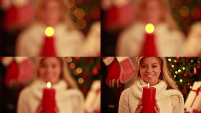漂亮的金发女郎在圣诞节拿着蜡烛