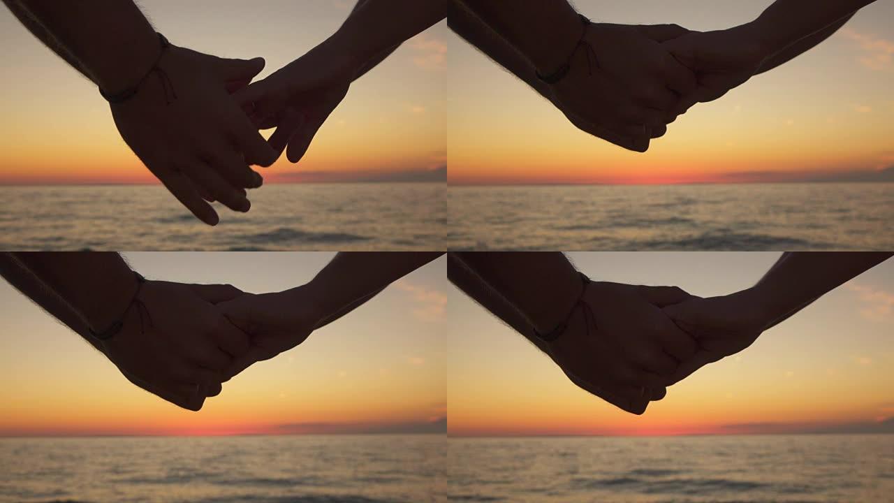 慢动作，特写: 爱的男孩和顽皮的女人在海洋海滩握着手