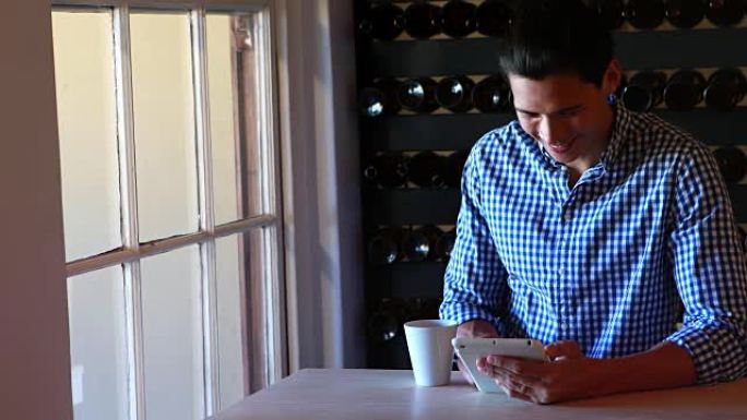 男人在喝4k咖啡时使用数字平板电脑