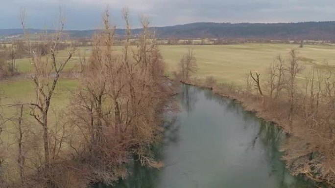 空中: 平静的河流蜿蜒穿过大山谷草地