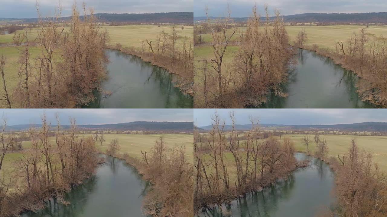 空中: 平静的河流蜿蜒穿过大山谷草地