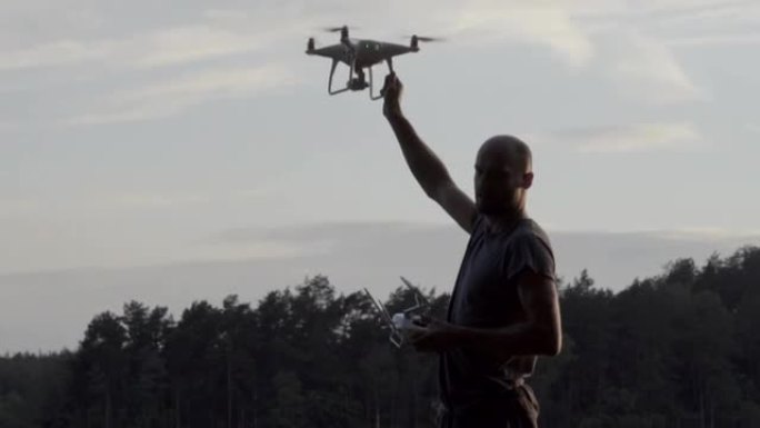 Young man working with drone on a lake coast