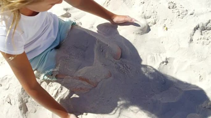女孩在海滩玩沙子